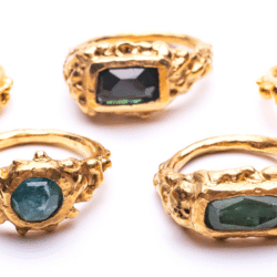 Three Gold Rings with green stones by Bea Jareno. An exhibitor at Craftworks.